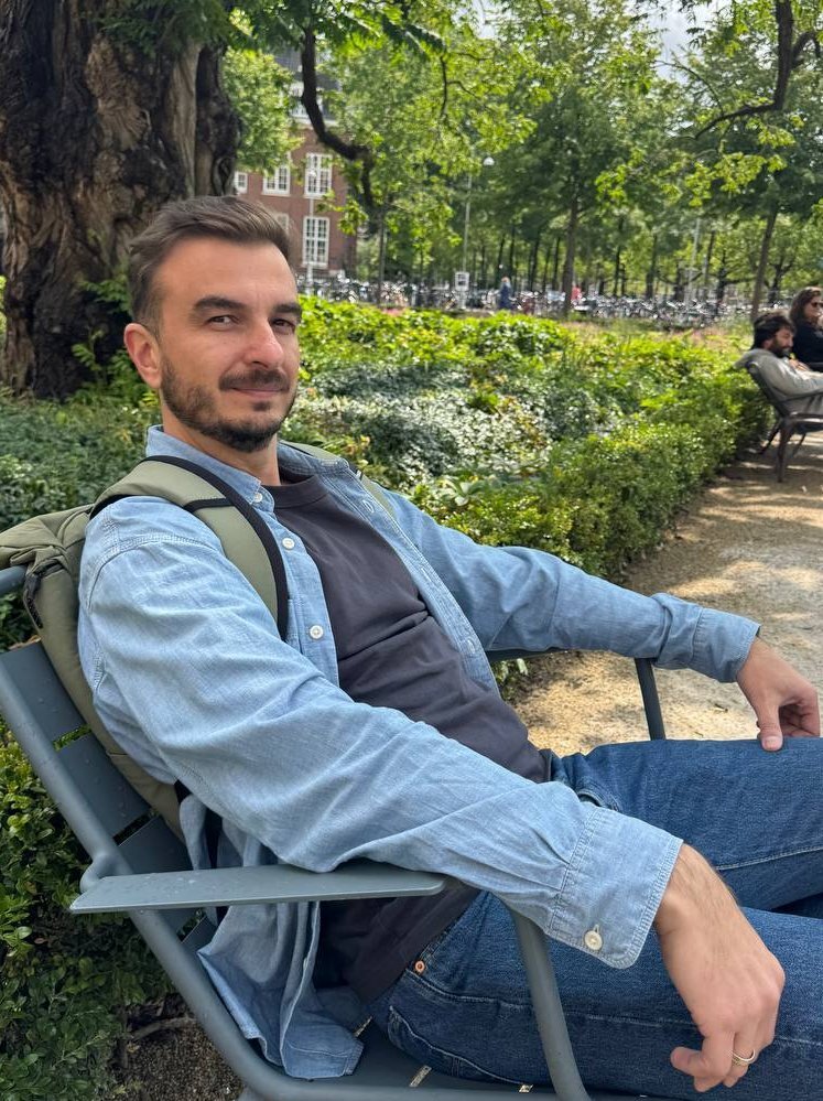 Photo of me sitting on a chair near the Rijksmuseum in Amsterdam.